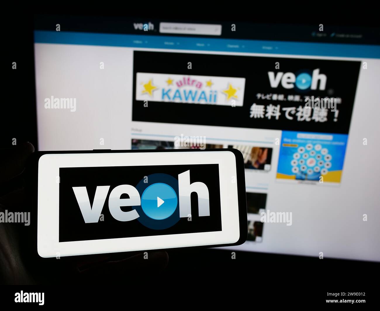 Person, die ein Smartphone mit dem Logo der US-amerikanischen Videofreigabeplattform Veoh Networks Inc. Vor der Website hält. Schwerpunkt auf dem Display des Telefons. Stockfoto