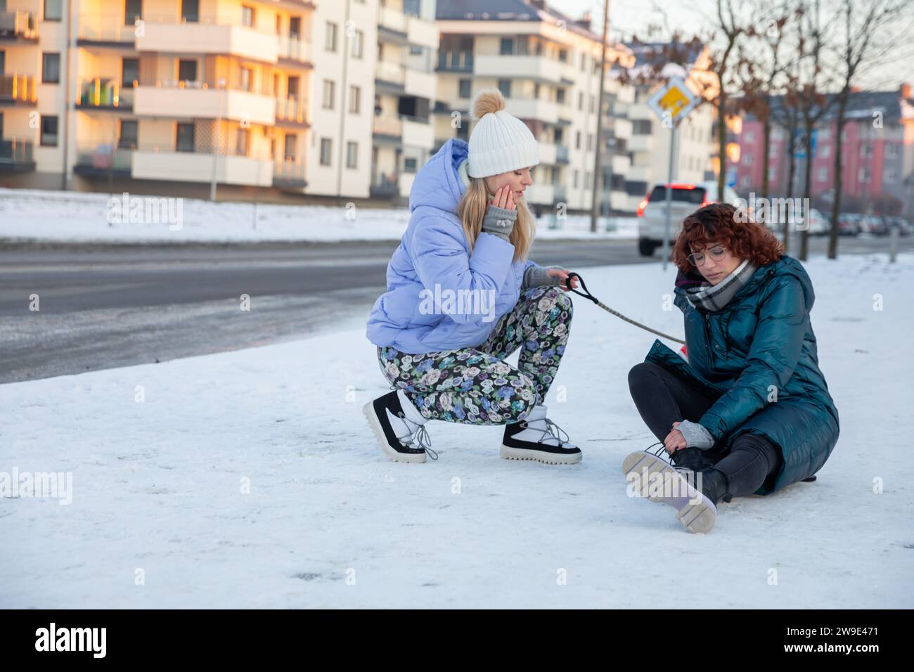 Ein Mädchen ist in den Schnee gefallen und hält ihr Bein. Stockfoto