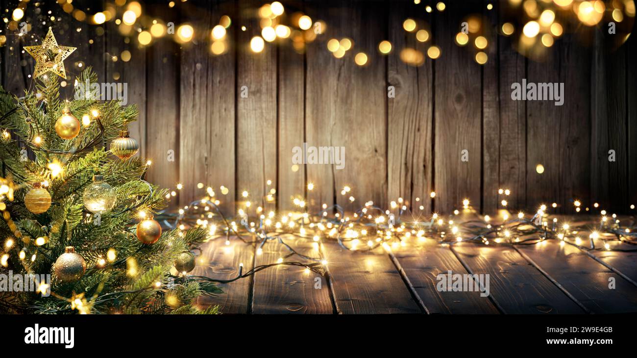 Weihnachten - Defokussiertes Lichterketten Auf Rustikalem Holztisch Mit Weihnachtsbaum Stockfoto