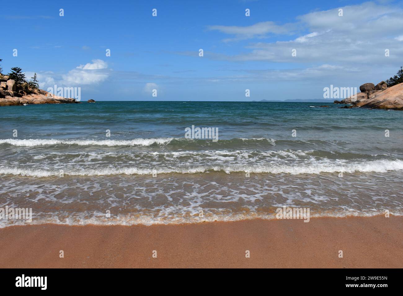 Blick auf den Strand und das Meer mit Wellen auf dem Sand in Alma Bay, Magnetic Island, Queensland, Australien Stockfoto