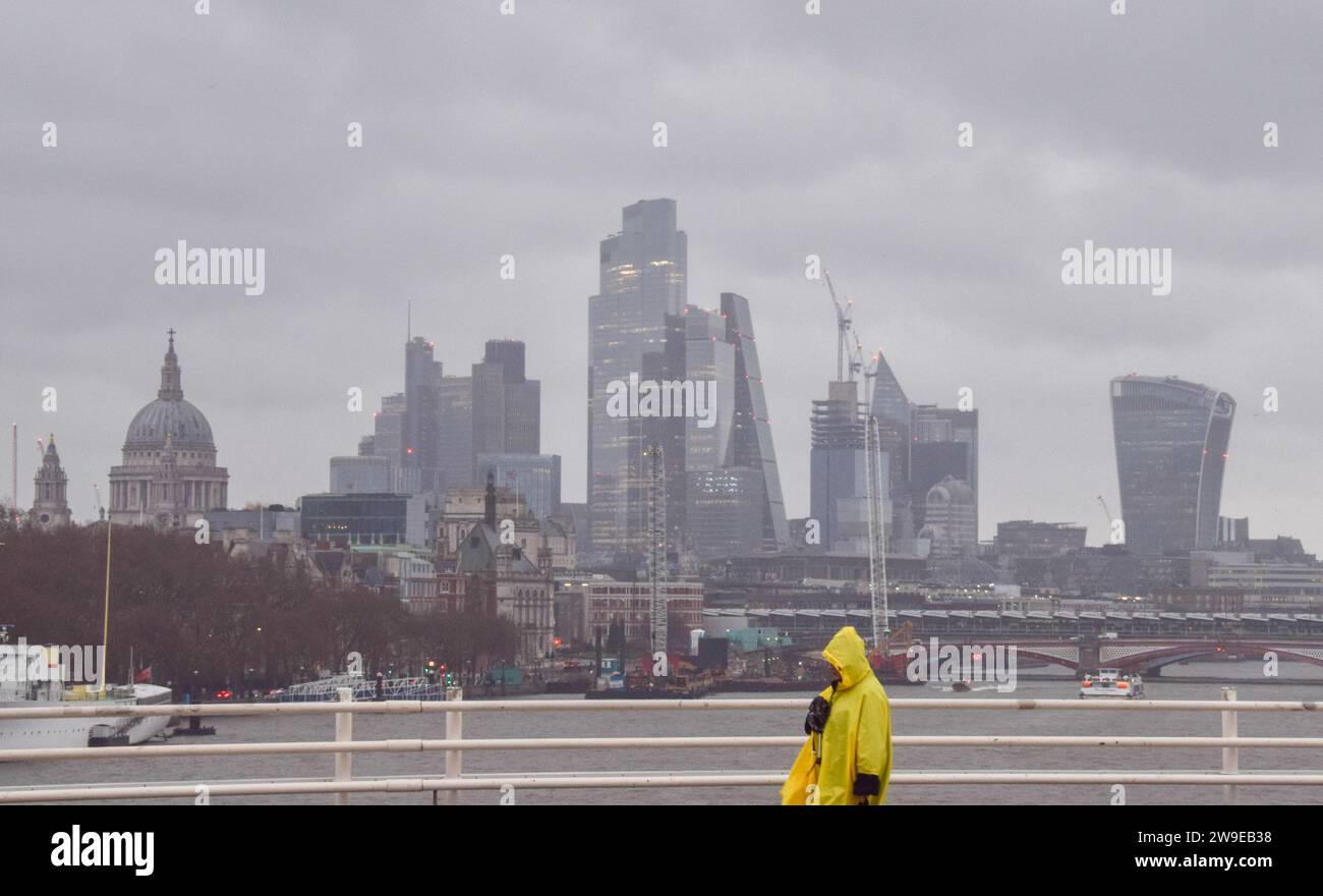 London, England, Großbritannien. Dezember 2023. Ein Preußer läuft über die Waterloo Bridge vorbei an der Skyline der City of London, dem Finanzviertel der Hauptstadt, und stürzt bei starkem Wind und Regen, wenn Storm Gerrit das Vereinigte Königreich trifft. (Kreditbild: © Vuk Valcic/ZUMA Press Wire) NUR REDAKTIONELLE VERWENDUNG! Nicht für kommerzielle ZWECKE! Stockfoto