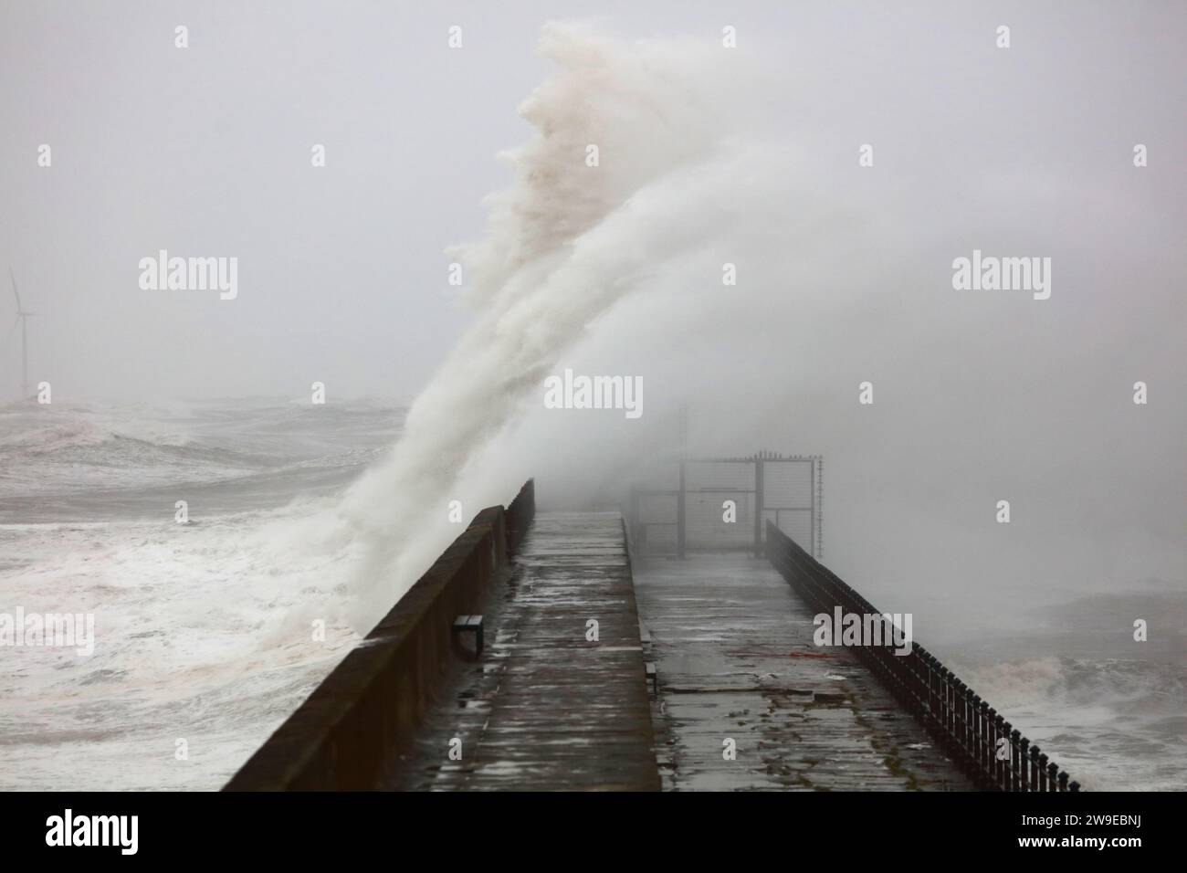 Riesige Wellen stürzten bei einem Sturm auf einem Steinpier in Hartlepool Headland, County Durham, England, Großbritannien. Stockfoto