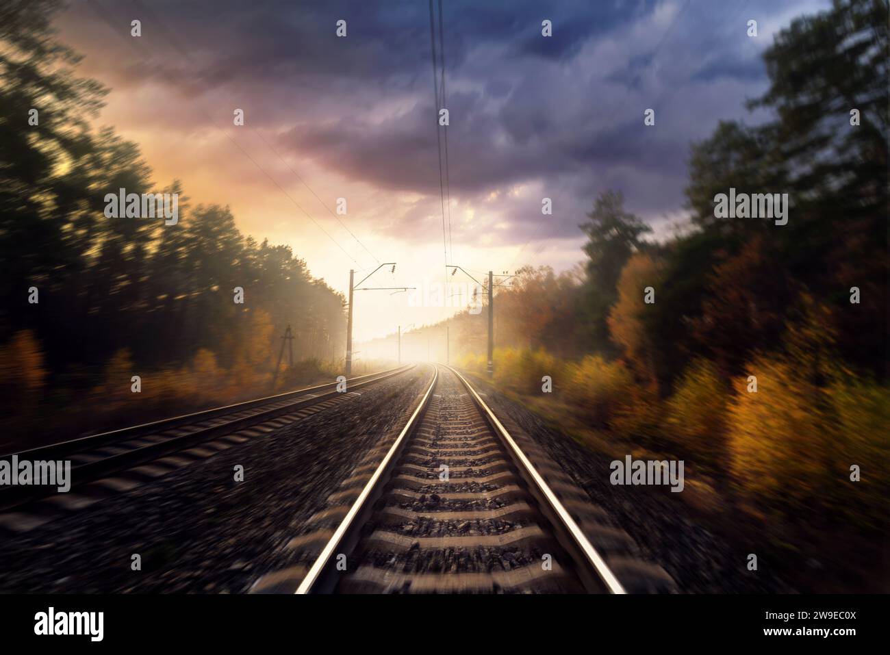 Eisenbahn im Herbstwald. Eisenbahngleise durch den Wald. Bewegungsunschärfeeffekt. Stockfoto