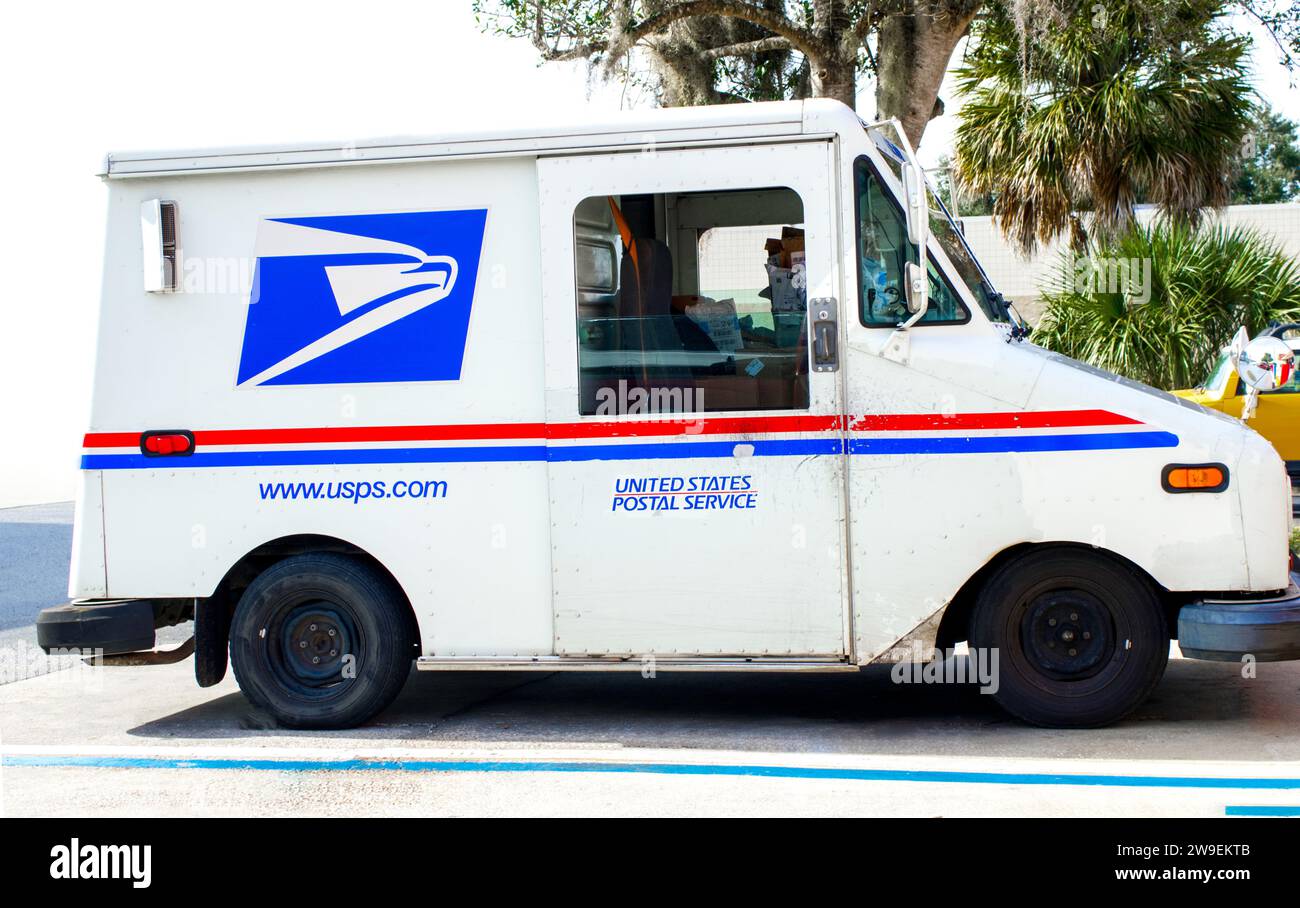Ocala, Florida, USA 2. November 2023 USPS-Lkw, der Post auf einer Vorstadtstraße auf einem besetzten Raum abstellt. Rot-weiß und blau mit am Stockfoto