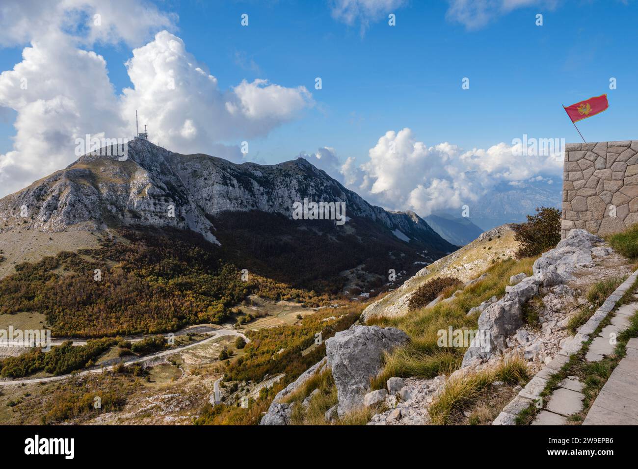 Blick auf den Berg Lovcen vom Gipfel des Jezerski Vrh mit einer montenegrinischen Flagge, die auf dem Njegos Mausoleum, Lovcen Nationalpark, Montenegro, fliegt Stockfoto
