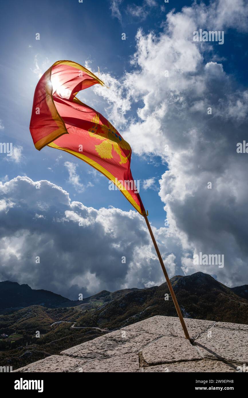 Eine montenegrinische Flagge, die am Njegos Mausoleum auf dem Gipfel des Jezerski vrh im Nationalpark Lovcen in Montenegro fliegt Stockfoto