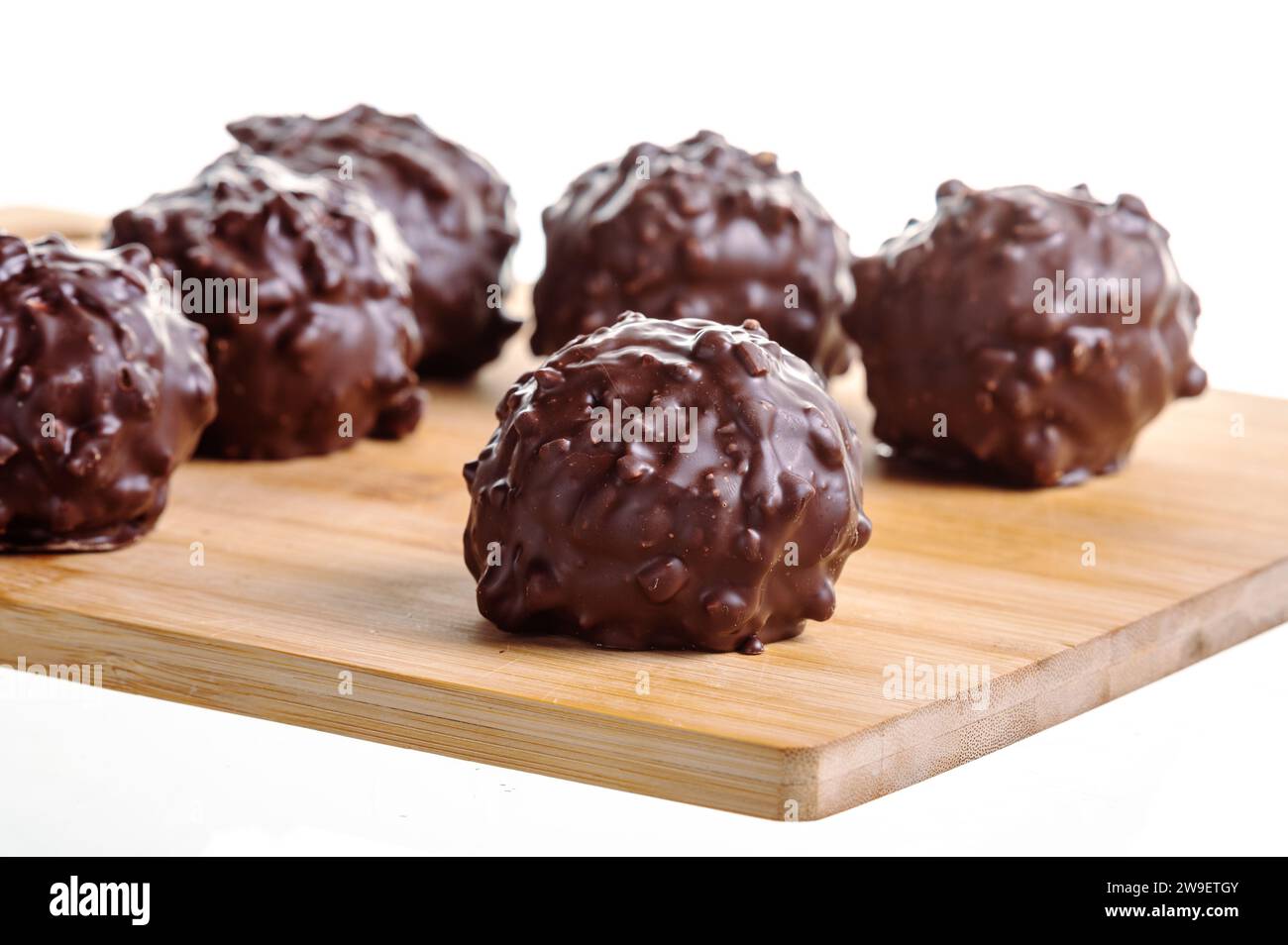 Schokoladenkugeln köstliche Pralinen auf einem Holztisch isoliert auf weiß Stockfoto