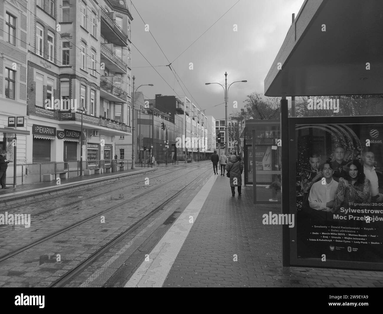 Ein Vintage-Schwarz-weiß-Foto von Menschen, die eine geschäftige Stadtstraße hinunterschlendern Stockfoto