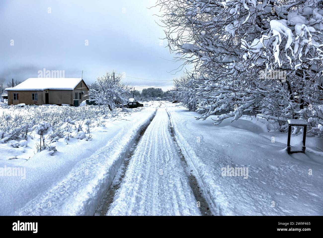 Die Straße im Dorf ist mit tiefem Schnee bedeckt Stockfoto