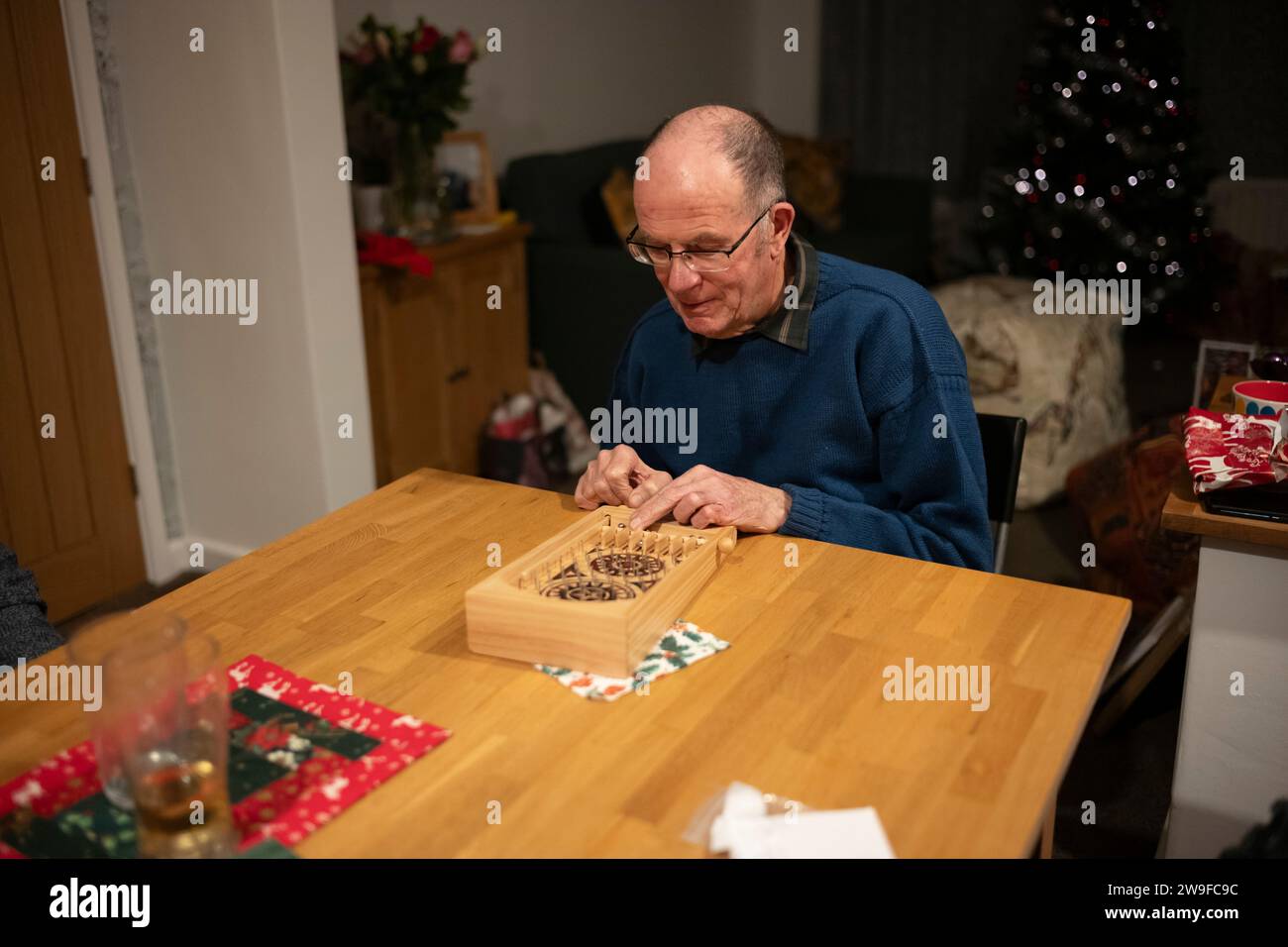 Großeltern spielen Tischplatten-Flipperspiel am Weihnachtstag, England, Großbritannien Stockfoto