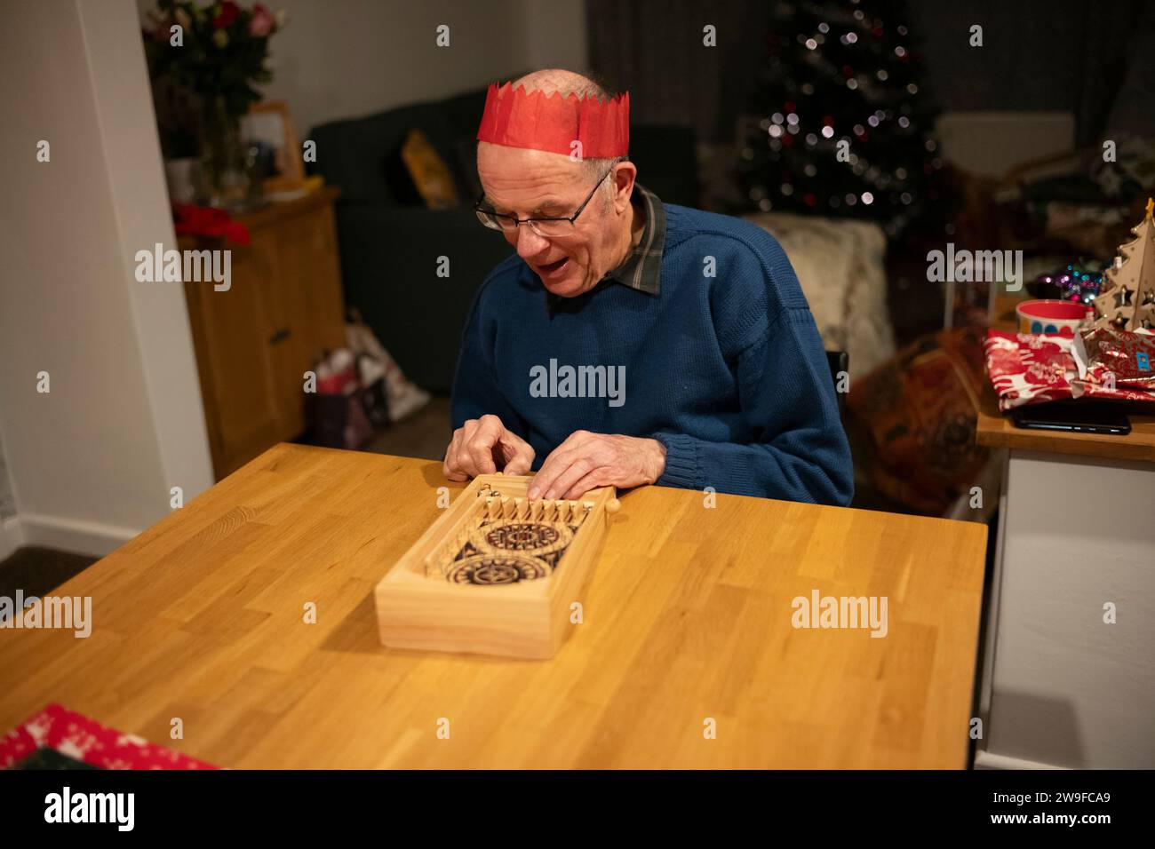 Großeltern spielen Tischplatten-Flipperspiel am Weihnachtstag, England, Großbritannien Stockfoto