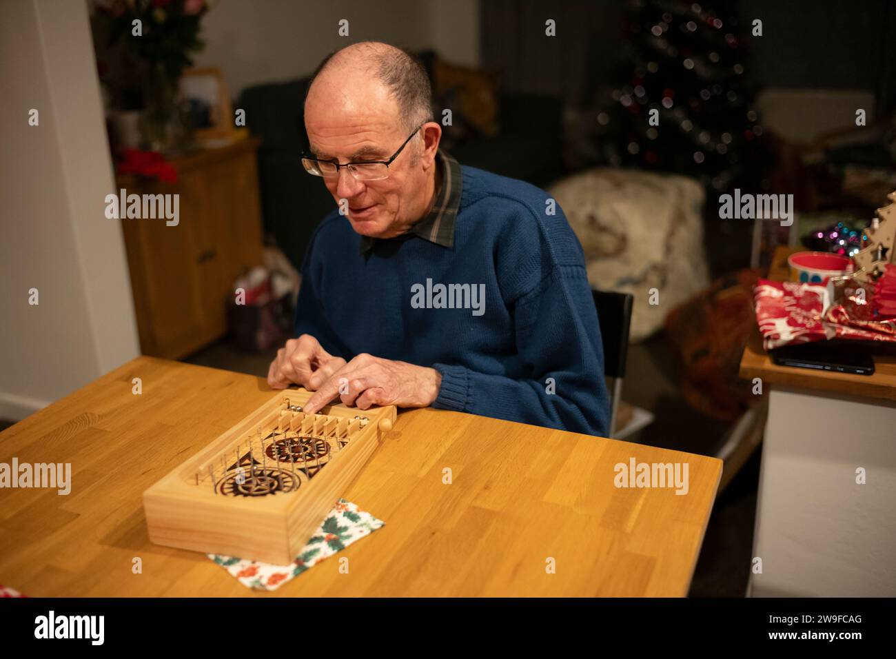 Großeltern spielen Tischplatten-Flipperspiel am Weihnachtstag, England, Großbritannien Stockfoto