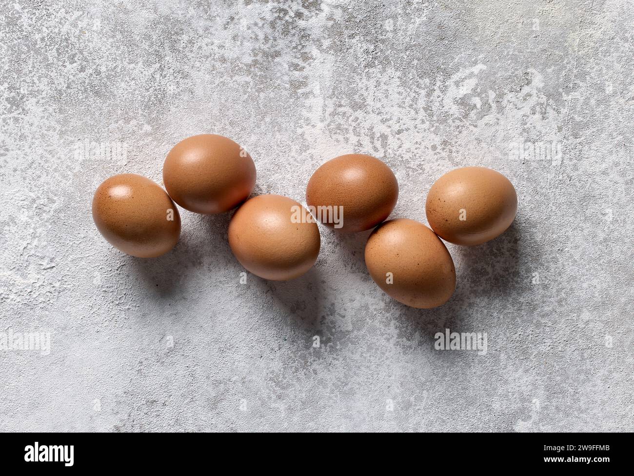 Braune Eier auf hellgrauem Küchentischhintergrund, Blick von oben Stockfoto