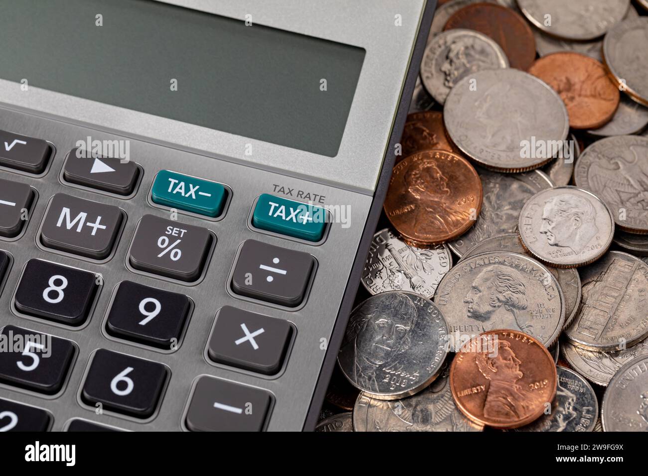 Steuerrechner mit Münzen. Einkommen-, Umsatz- und Grundsteuer-Konzept. Stockfoto