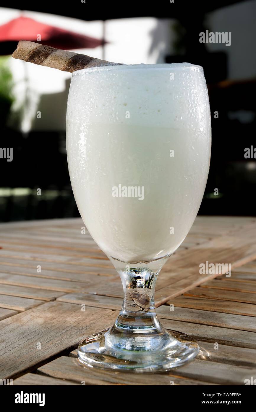 Ein Milchshake mit Vanillegeschmack wird auf den Tisch gestellt Stockfoto
