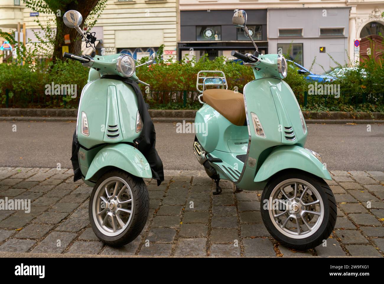 Geparkte Roller European Street. Zwei Vespas parkten auf einer Straße in der Innenstadt in einer europäischen Stadt. Stockfoto