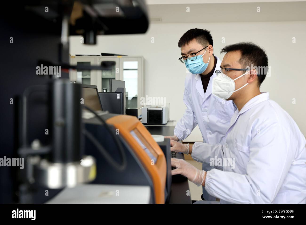 ZAOZHUANG, CHINA - 28. DEZEMBER 2023 - zwei Studenten analysieren Daten von biologisch abbaubaren Materialien in einem privaten Unternehmenslabor in Xiwangzhuan Stockfoto