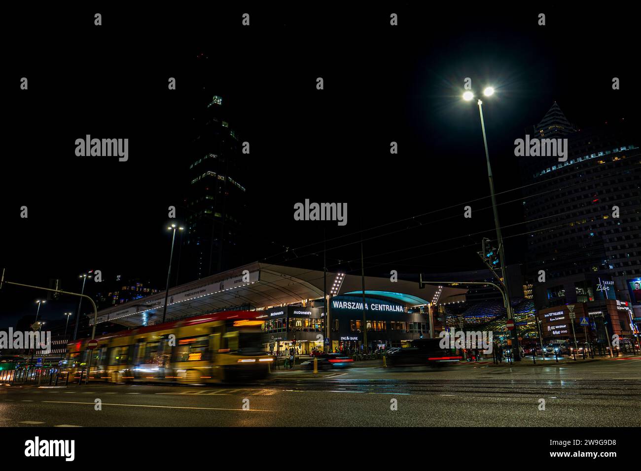 Warschau, Polen - 26. Dezember 2023: Blick auf den Hauptbahnhof mit verschwommenen Formen beweglicher Fahrzeuge im Vordergrund. Stockfoto