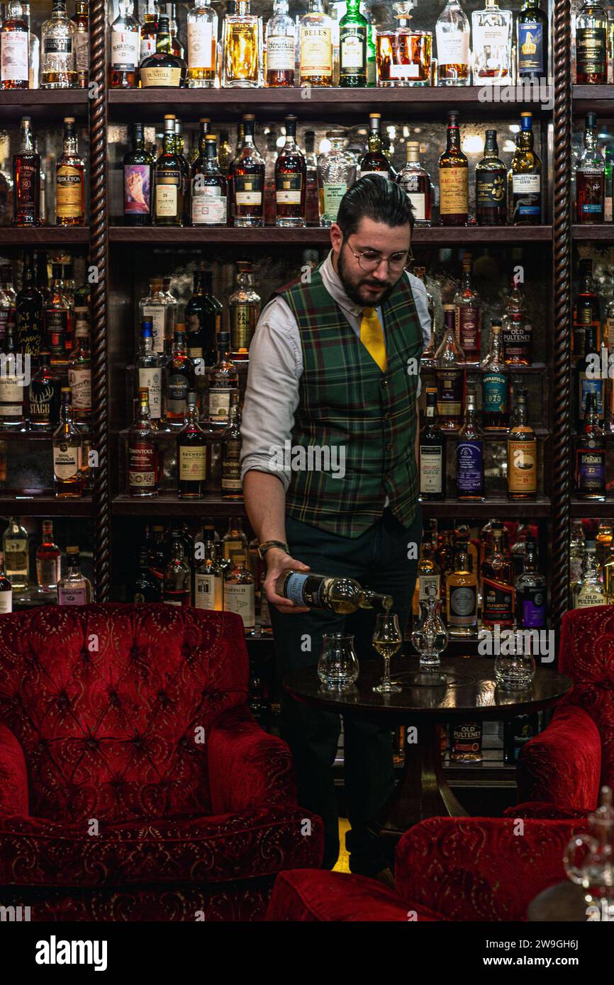 Der Barkeeper schenkt Whisky in Bertie's Whisky Bar, Fife Arms, Braemar, Schottland. Stockfoto