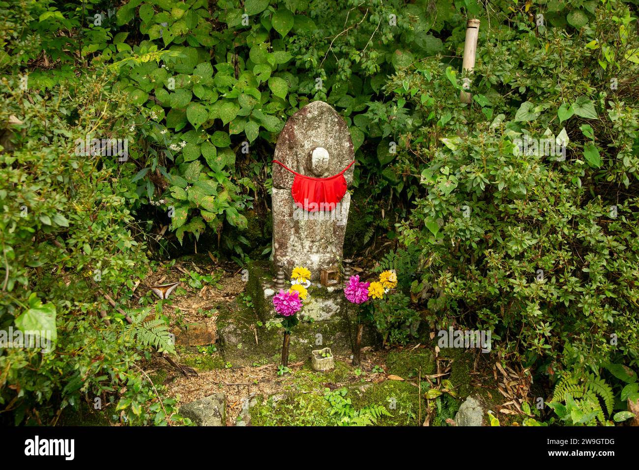 Stein mit religiösen Motiven in einem Wald in Japan gemeißelt. Stockfoto