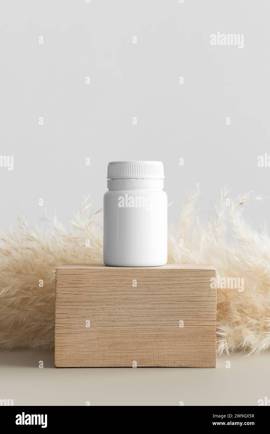 Weißes Modell der Pille-Flasche mit Pampas-Dekoration. Stockfoto
