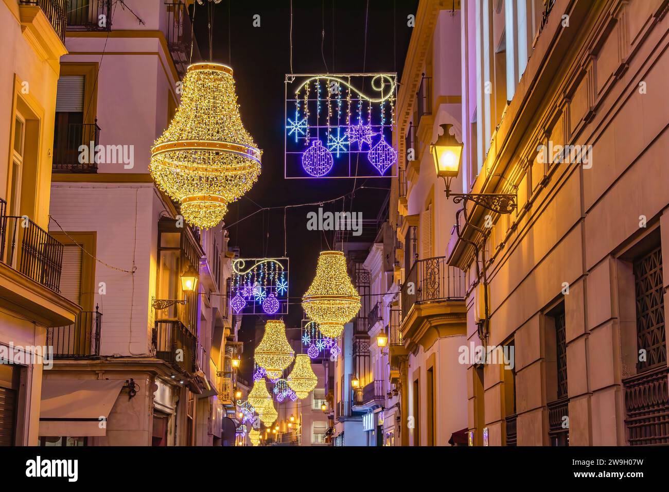 Sevilla, Spanien - 16. Dezember 2023: Weihnachtsbeleuchtung in der Sierpes Street in Form eines goldenen Kristallleuchters im Empire-Stil in Sevilla Stockfoto