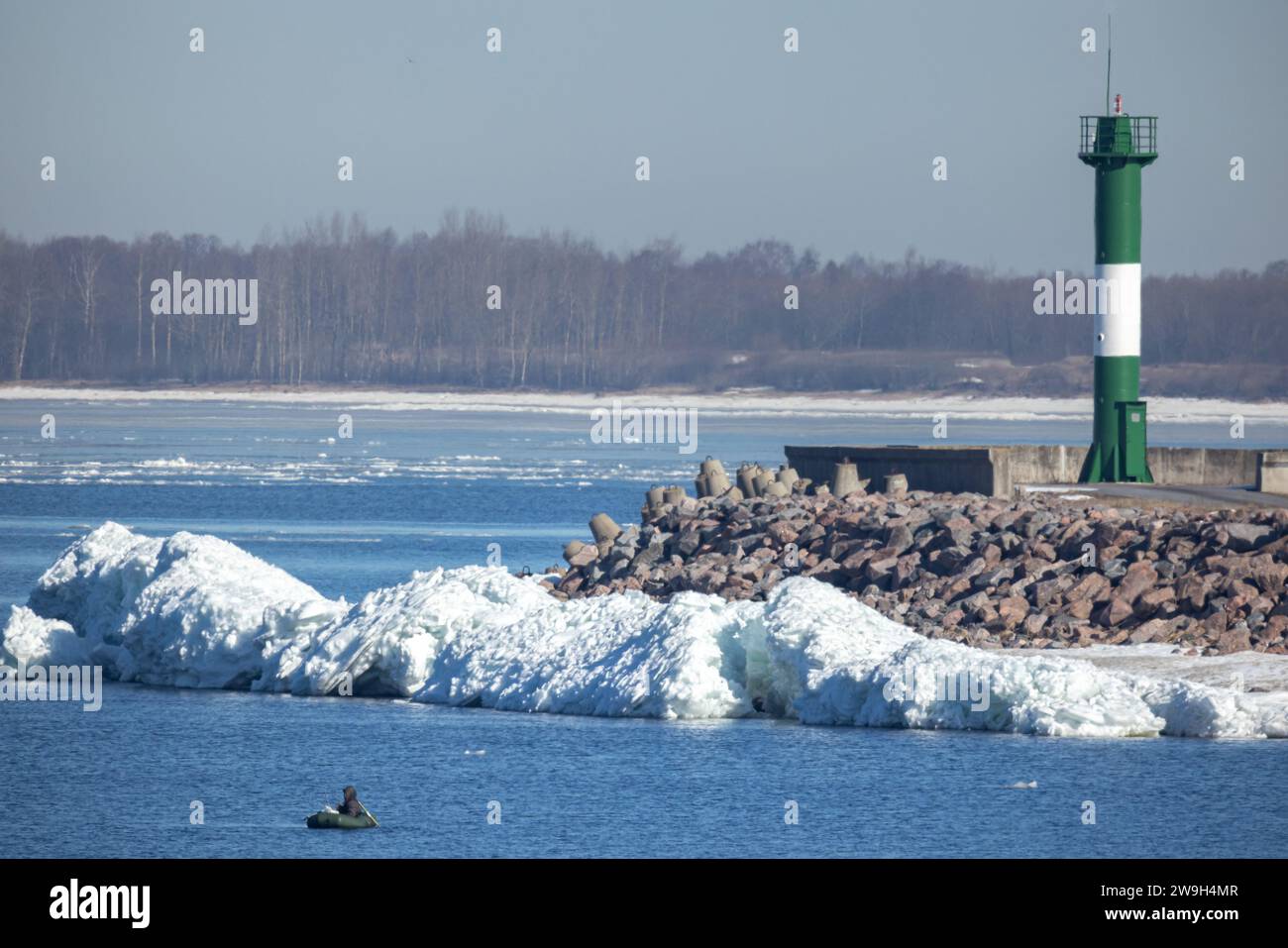 Küstenschifffahrtsmarke, gestreifter grün-weißer Leuchtturm an einem Wintertag Stockfoto