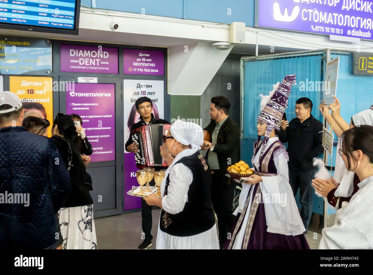 Kasachische Frauen in traditioneller Kleidung während der Zeremonie des Treffens und Begrüßens eines Bräutigams auf einem Flughafen in Aqtobe Kasachstan Stockfoto