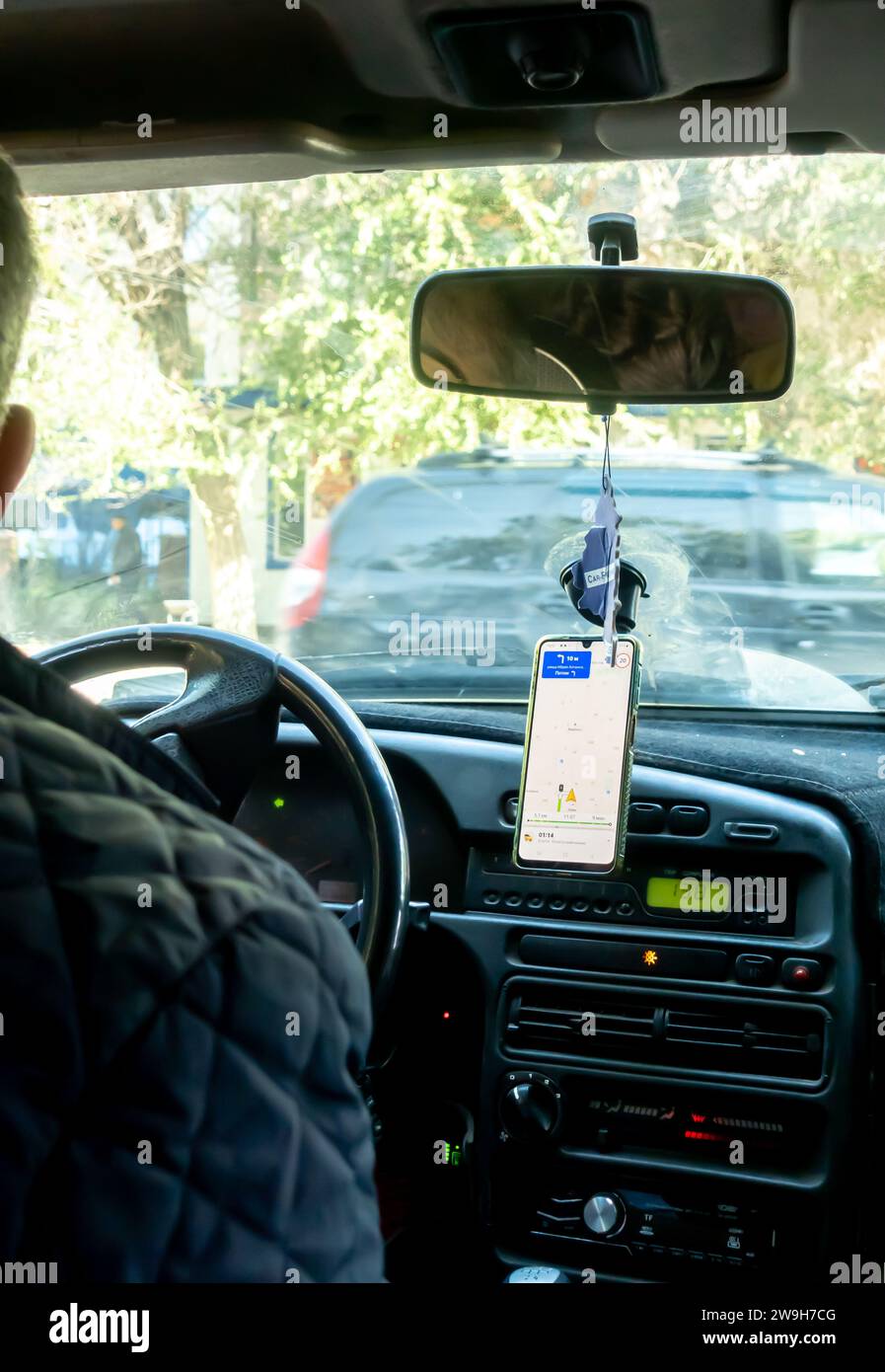 Ein Fahrer, der in einem Auto den Navigator eines Smartphones verwendet Stockfoto