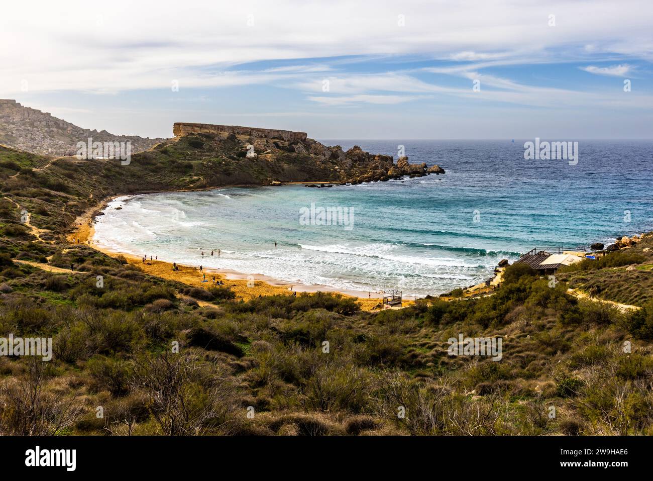 Għajn Tuffieħa Bucht. Strand mit dunklem Sand, beliebt zum Surfen und in einer Bucht, die von Hügeln umgeben ist, mit einem Küstenpfad in der Nähe von L-Imġarr, Malta Stockfoto