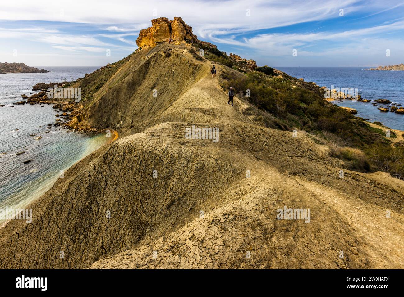 Għajn Tuffieħa-Bucht mit Il-Qarraba-Felsen. Strand mit dunklem Sand, beliebt zum Surfen und in einer Bucht, die von Hügeln umgeben ist, mit einem Küstenpfad in der Nähe von L-Imġarr, Malta Stockfoto