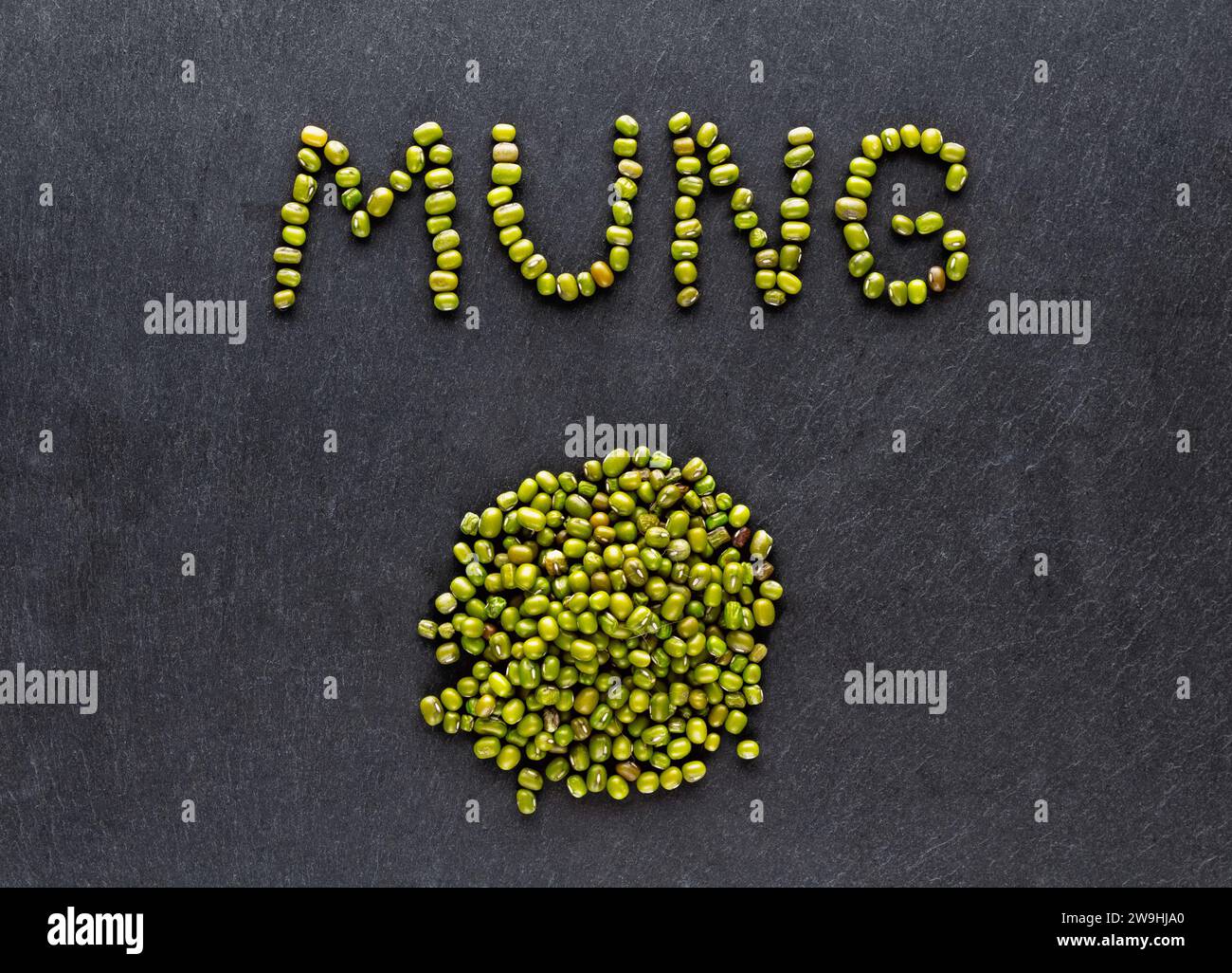 Getrocknete grüne Mungbohnen auf dunklem Steinhintergrund. Gesundes Lebensmittelkonzept. Flache Lagen. Stockfoto