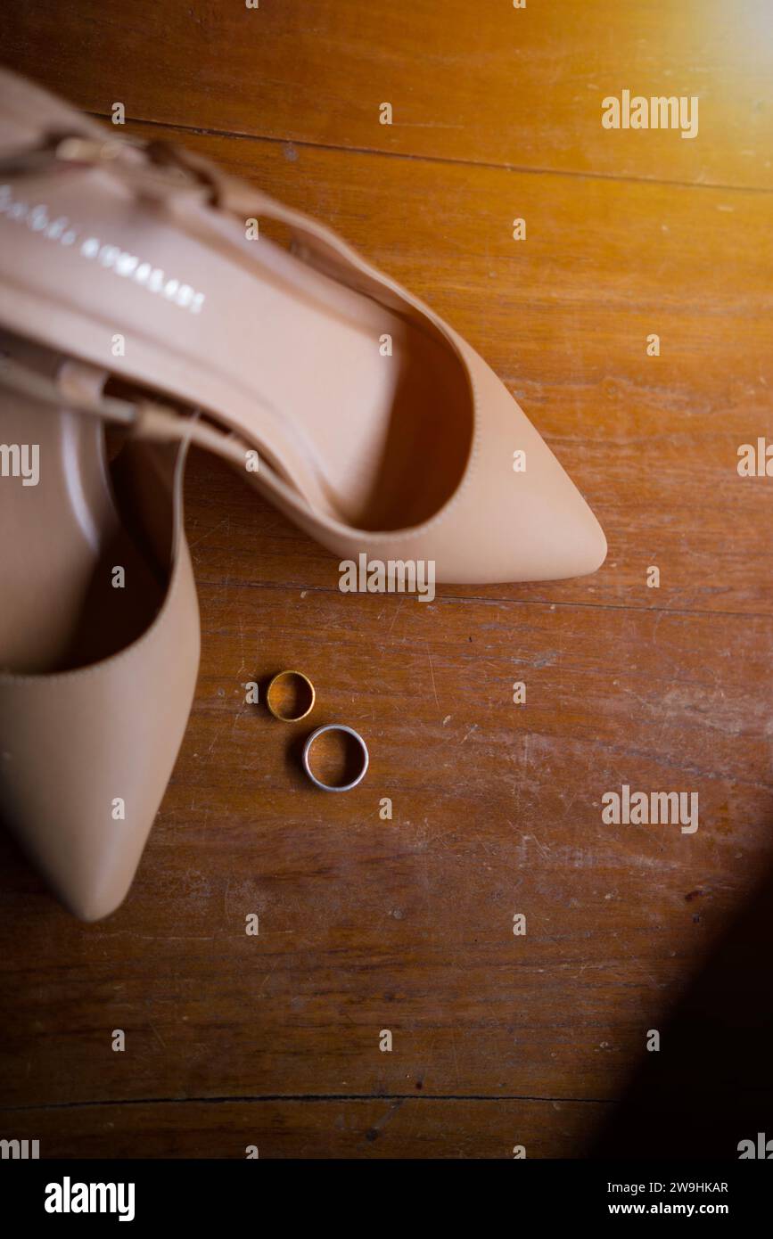 Brautschuhe mit einem Paar Ringe auf einem Tisch mit optischer Blende Stockfoto