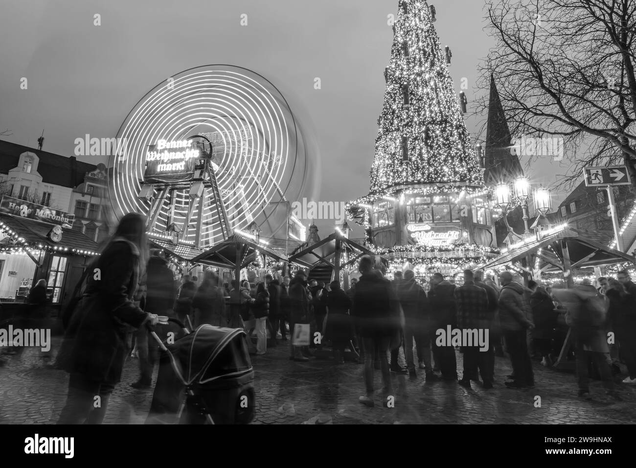 Bonn, Deutschland - 16. Dezember 2023 : Blick auf einen beleuchteten Weihnachtsbaum und ein Riesenrad auf dem Bonner Weihnachtsmarkt Stockfoto