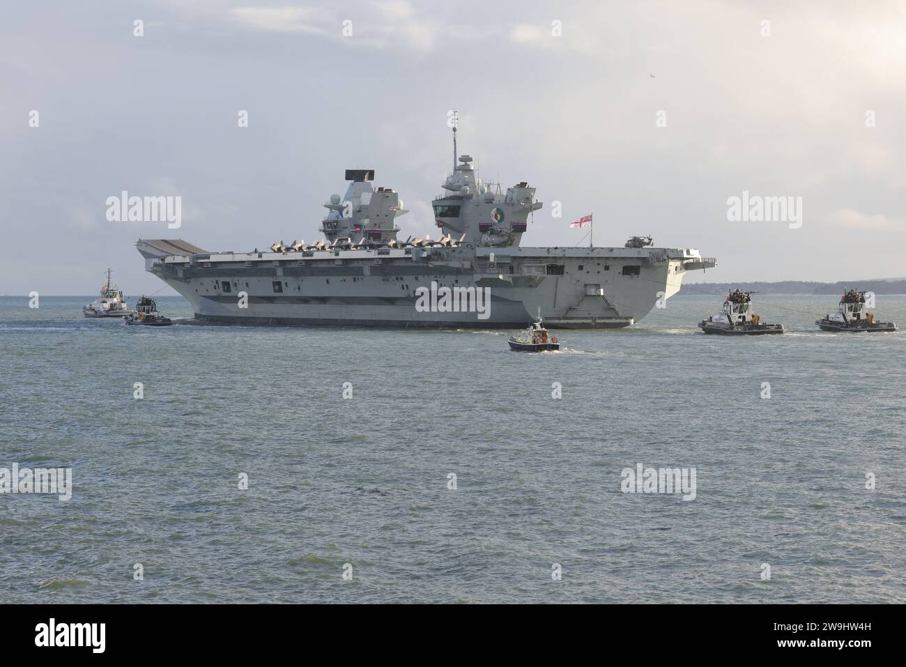 Schlepper eskortieren den Flugzeugträger HMS QUEEN ELIZABETH aus der Marinebasis mit einer Staffel von F35B Lightning Jets auf dem Flugdeck Stockfoto Schlepper eskortieren den Flugzeugträger HMS QUEEN ELIZABETH aus der Marinebasis mit einer Staffel von F35B Lightning Jets auf dem Flugdeck Stockfoto