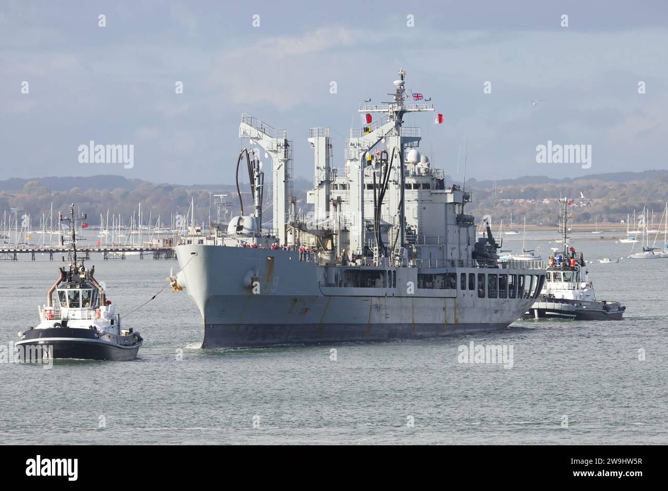 Hafenschlepper eskortieren das Schnellkampfschiff ROKS HWACHEON aus dem Hafen nach einem kurzen Besuch der Marinebasis Stockfoto