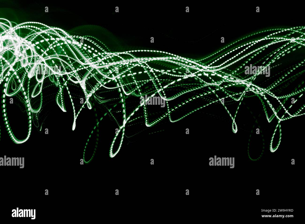 Ein Foto mit leuchtend grünen gepunkteten Linien auf einem Foto mit langer Belichtung. Lichtmalerei Stockfoto