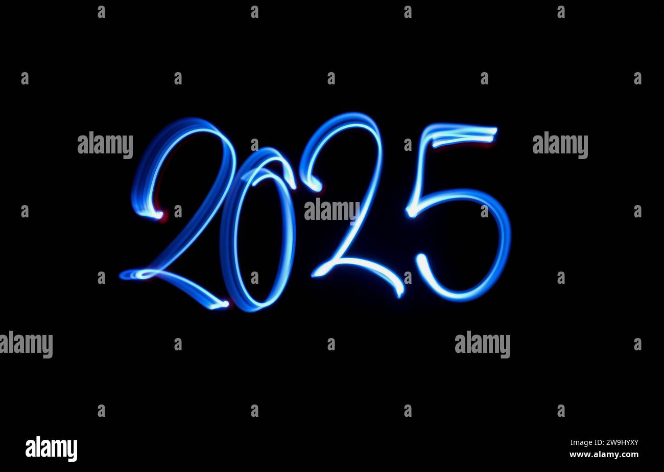Ein Foto von „2025“ in leuchtendem blauem Licht auf einem Langzeitfoto vor schwarzem Hintergrund. Lichtmalerei Stockfoto