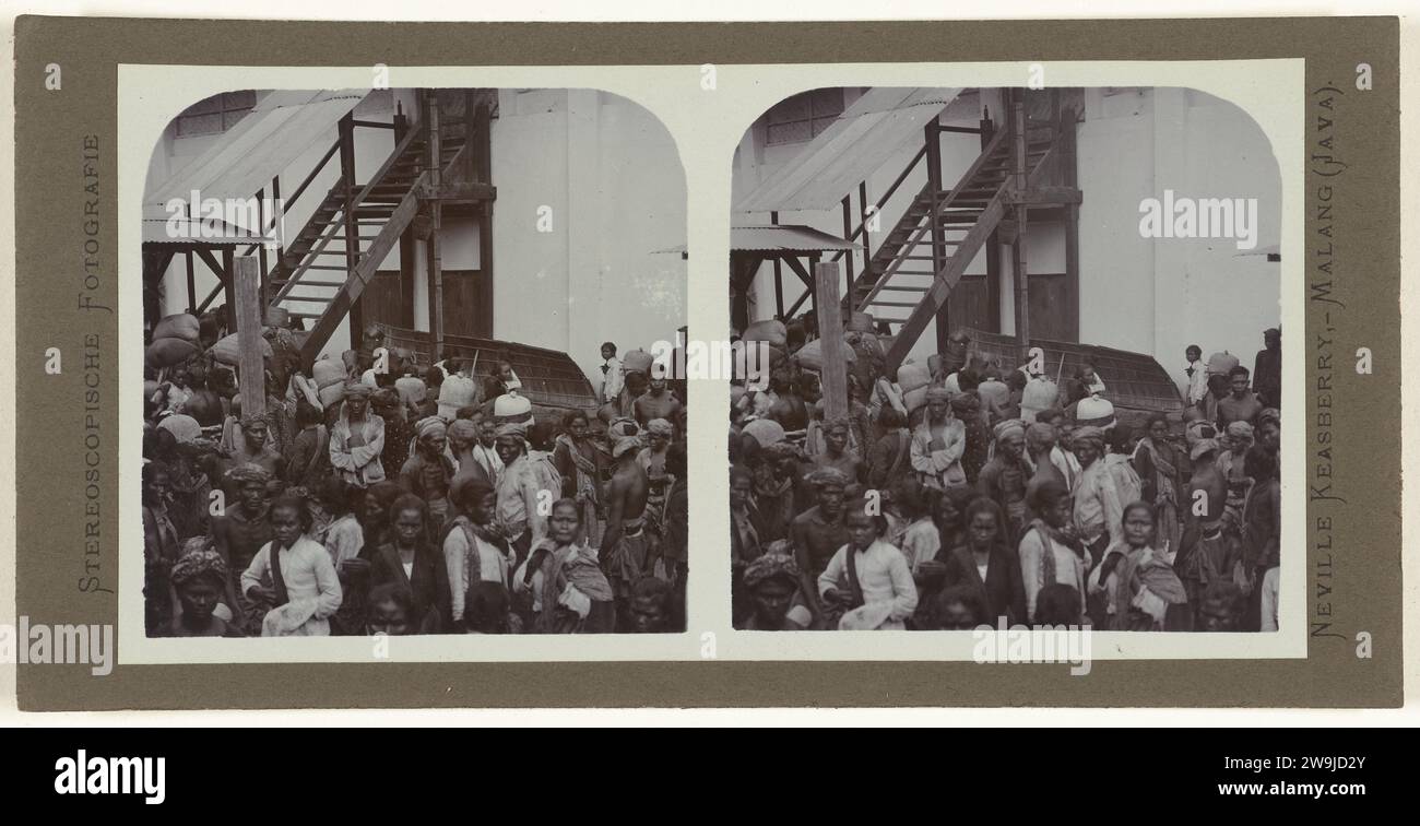 Die Kaffeepflöte in großen Taschen auf der Rückseite durch javanische Mitarbeiter., 1900 - 1935 Foto. Stereograph javanische Restaurants unter freiem Himmel auf einem belebten Gelände. Malang (möglicherweise) Papier. Unterstützung für Fotos. Albumendruck aus Pappe Stockfoto