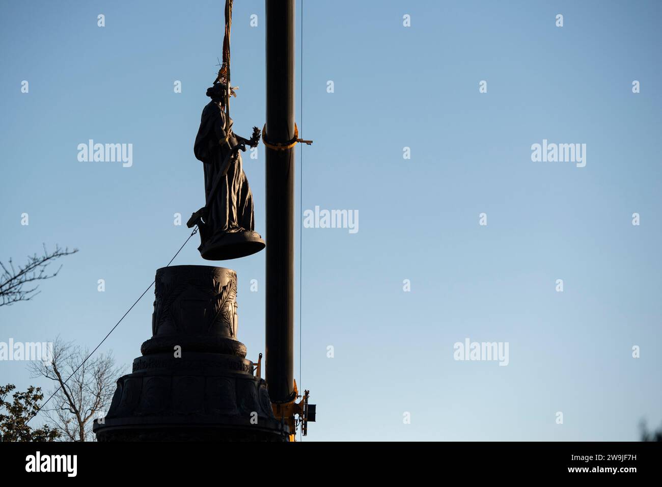 Arlington, Vereinigte Staaten von Amerika. Dezember 2023. Die Bronzestatue auf dem Confederate Memorial im Abschnitt 16 des Arlington National Cemetery wird während der Entfernung am 20. Dezember 2023 in Arlington, Virginia, mit einem Kran angehoben. Die Gedenkstätte zu Ehren von Mitgliedern der Konföderierten Staaten von Amerika wird in den New Market Battlefield State Historic Park verlegt. Kredit: Elizabeth Fraser/USA Army/Alamy Live News Stockfoto