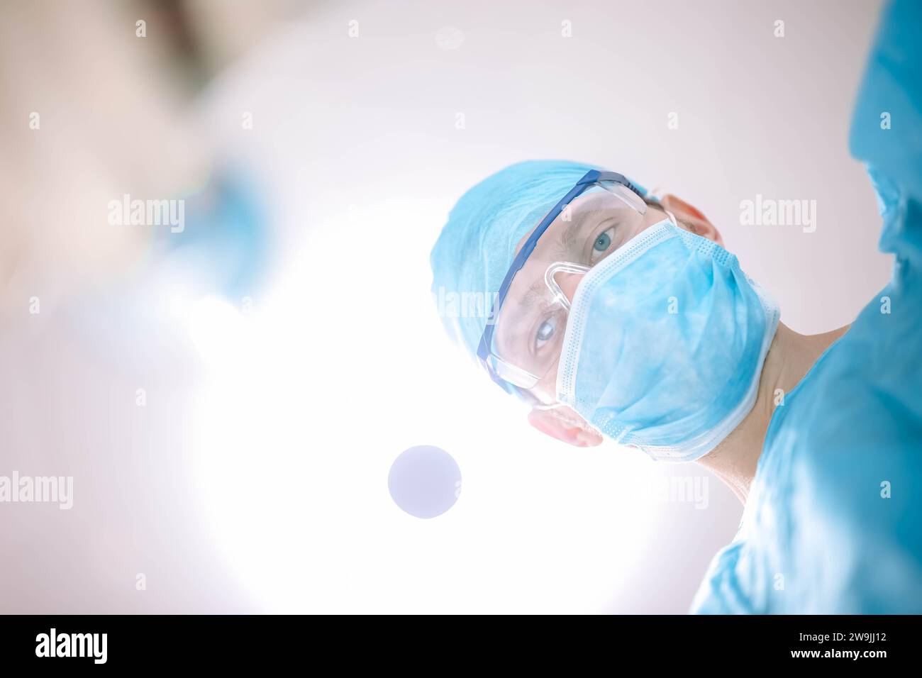 Männlicher Chirurgenarzt im Operationssaal, der den Patienten in die Kamera sieht Stockfoto