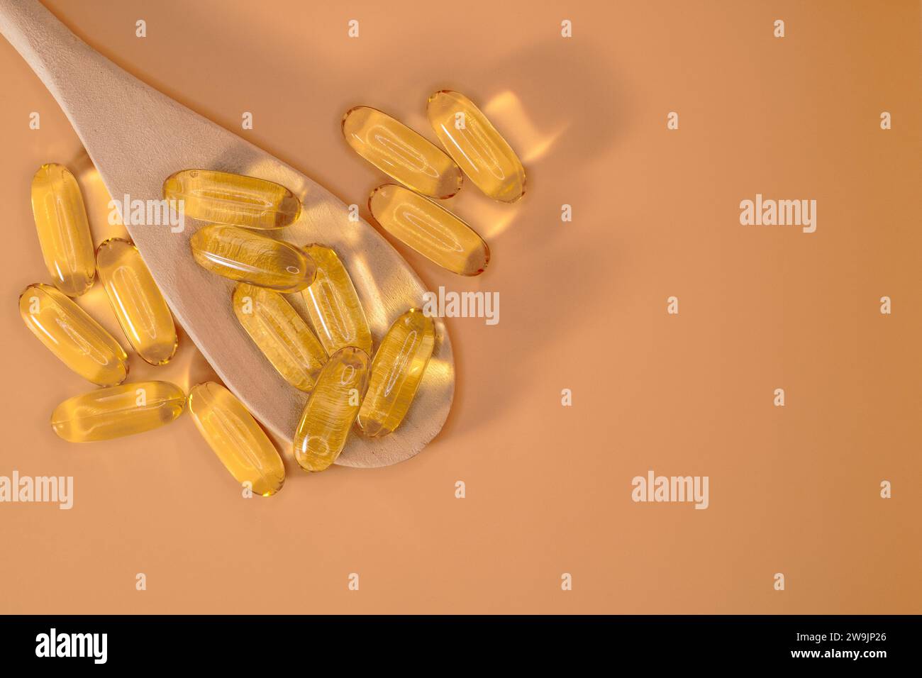 Omega-3-Fischöl-Gel-Kapseln auf neutralem Pfirsichhintergrund. Kabeljau-Lebertabletten, Vitamine und Nahrungsergänzungsmittel. Set mit Omega 3-6-9 Fischleberöl Kapseln Stockfoto