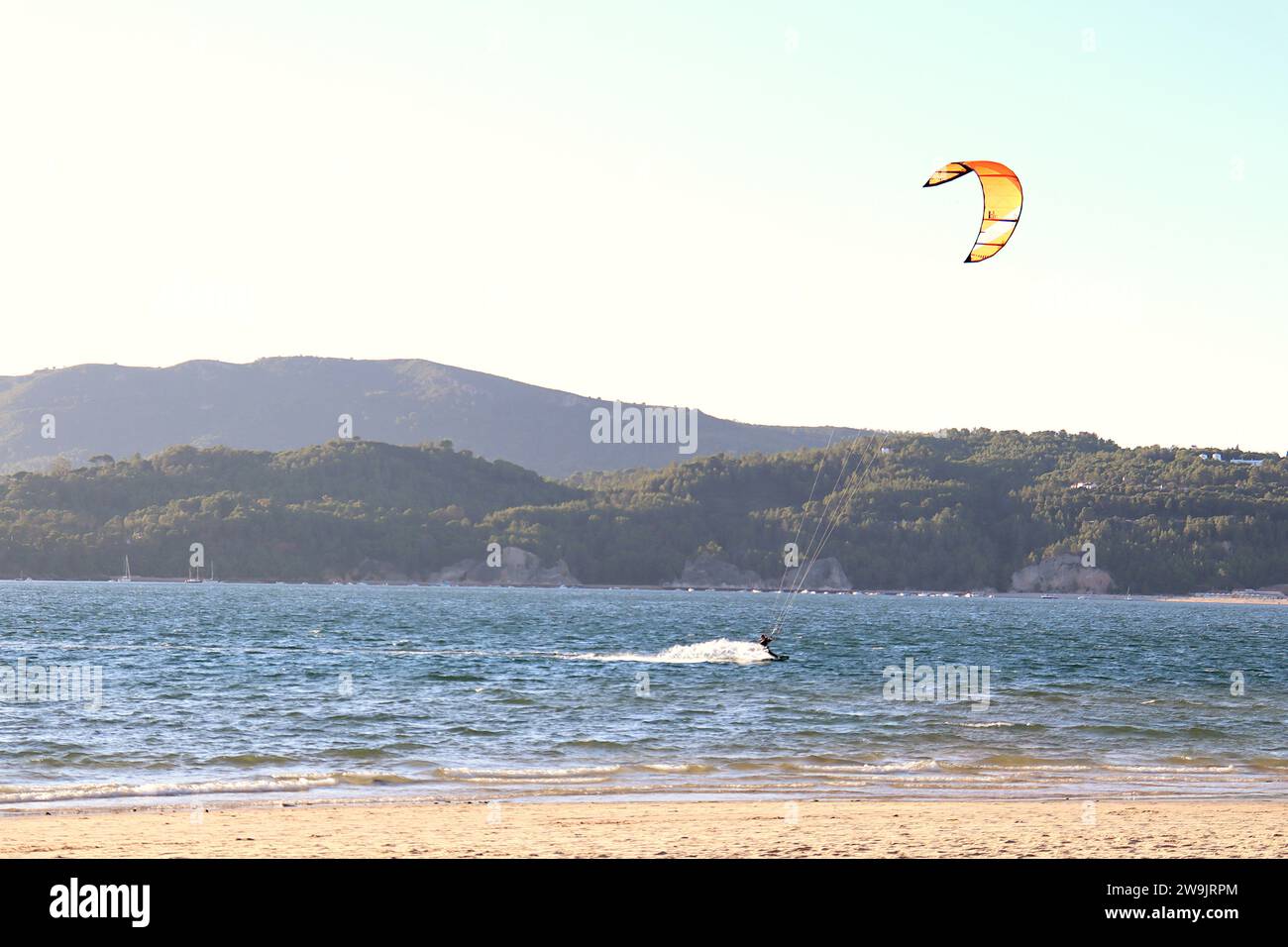 Kiteboarden an der Mündung des Flusses Sado in Tróia, Portugal, mit der Serra da Arrábida im Hintergrund. Stockfoto