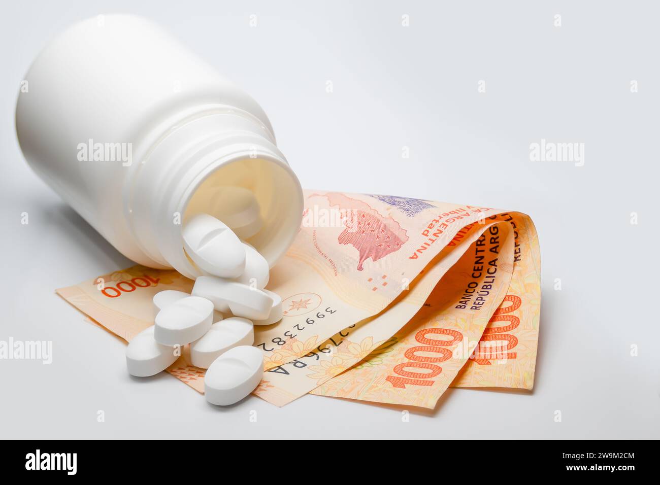 Teures Medizinkonzept mit Pillen und argentinischen Peso-Rechnungen. Stockfoto