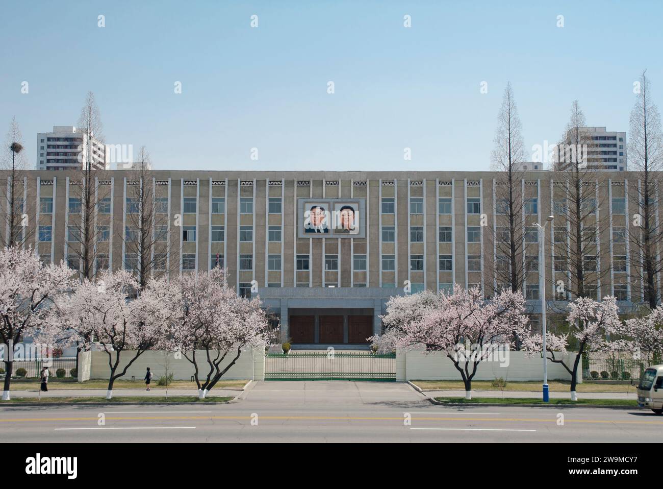 Porträts der ehemaligen Führer Kim il-Sung und Kim Jong-Il hängen an einem Gebäude in einer Straße im Zentrum von Pjöngjang in Nordkorea. Stockfoto