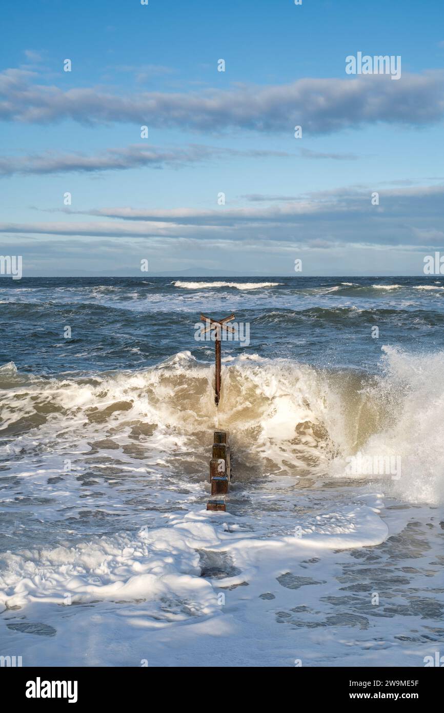 Seeverteidigungskühe und Wellen im windigen Meer am Findhorn Strand. Morayshire, Schottland Stockfoto