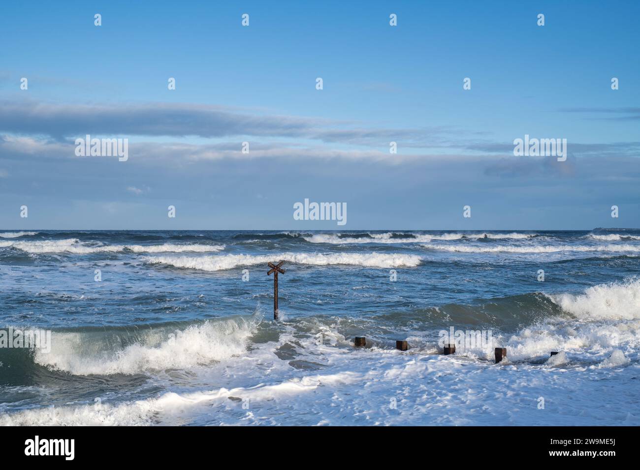 Seeverteidigungskühe und Wellen im windigen Meer am Findhorn Strand. Morayshire, Schottland Stockfoto
