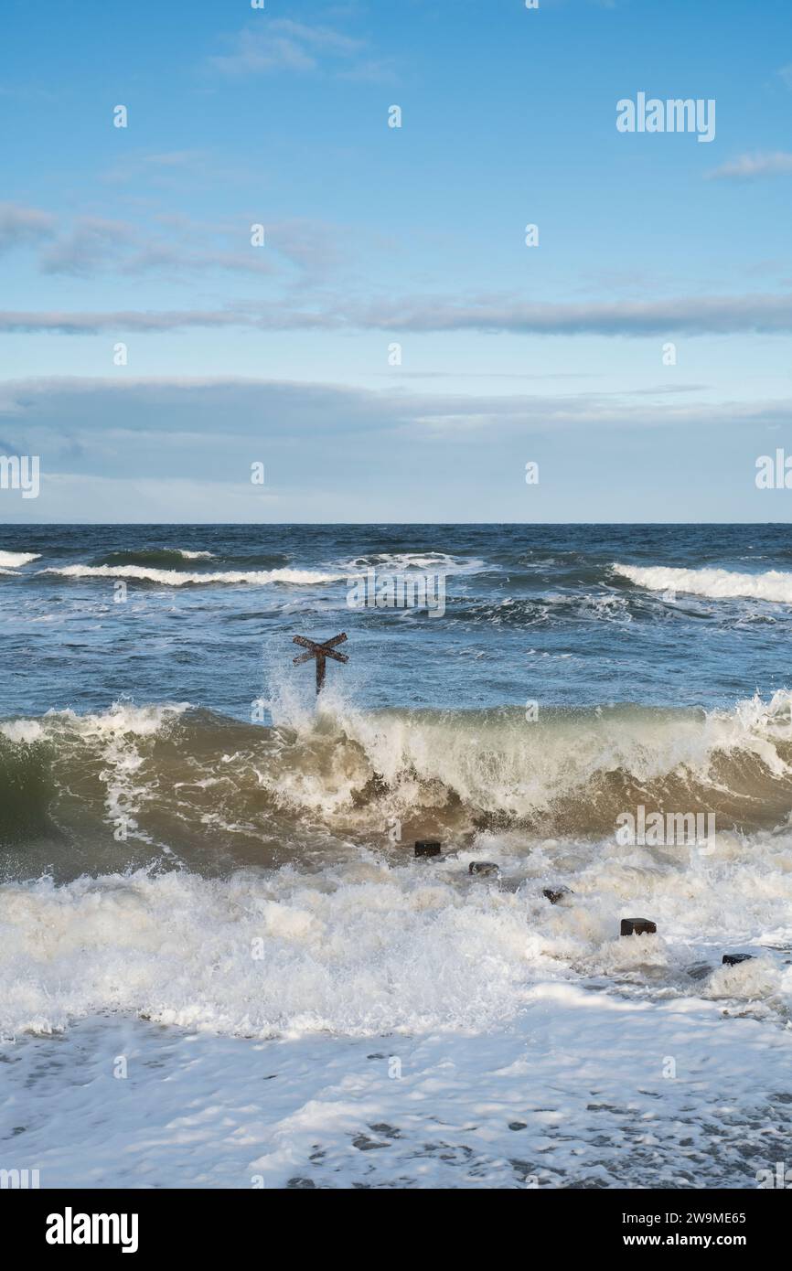 Seeverteidigungskühe und Wellen im windigen Meer am Findhorn Strand. Morrayshire, Schottland Stockfoto