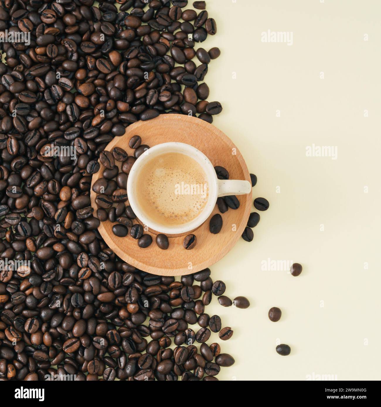 Kreatives Layout aus einer Tasse Kaffee und Kaffeebohnen auf hellem cremefarbenen Hintergrund. Minimales Konzept. Trendige flache Komposition. Kaffeeästhetik. Stockfoto