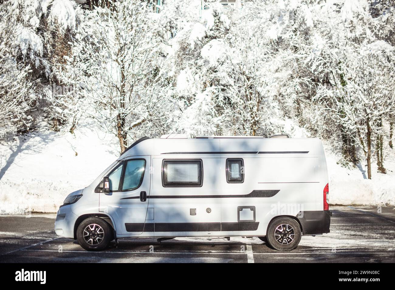 Nahaufnahme eines weißen Wohnwagens, der im Winter in Österreich auf einem Parkplatz geparkt wurde Stockfoto